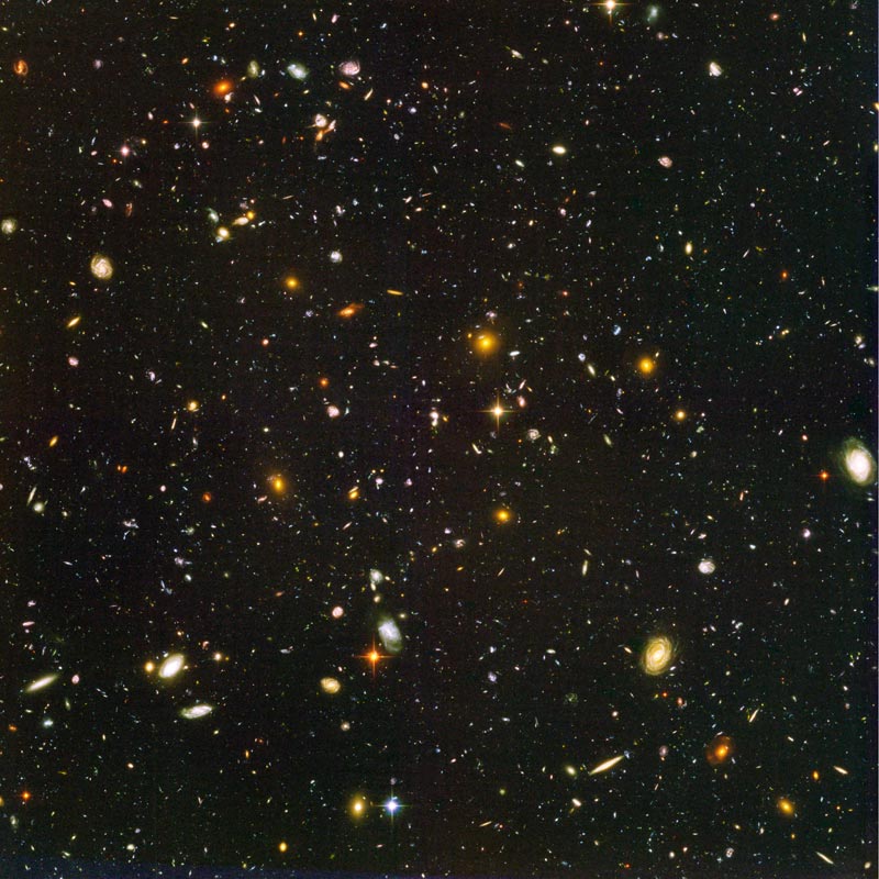 Hubble Ultra Deep Field: a dense scattering of distant galaxies in black space. Context image, not an image of the unidentified source.