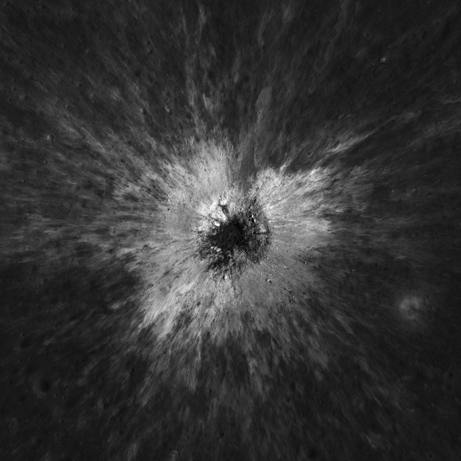 Bright ejecta surrounding the dark center of the newly formed McGetchin lunar crater.